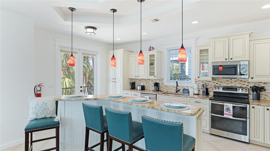 4101 4th Avenue Holmes Beach, FL 34217 - Photo 9 of 60 a kitchen with stainless steel appliances granite countertop a stove a sink and a refrigerator