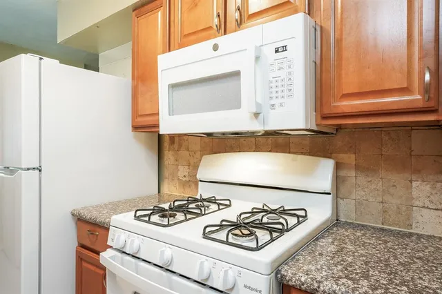 a stove top oven sitting inside of a kitchen