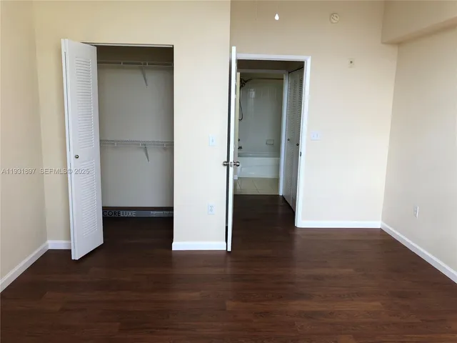 an empty room with wooden floor & closet