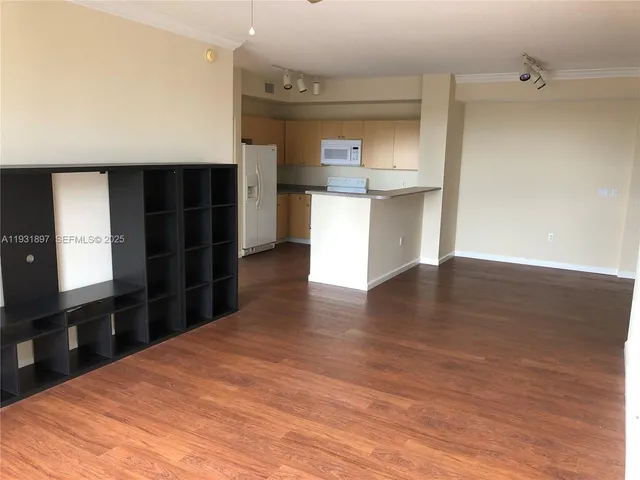 a view of a kitchen with cabinets and wooden floor