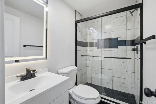 a bathroom with a sink a toilet and shower