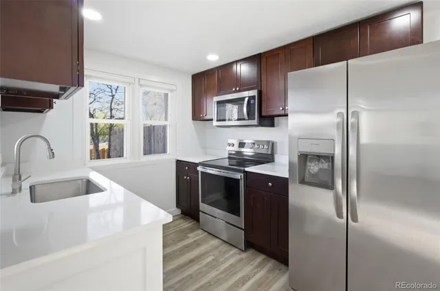 a kitchen with stainless steel appliances granite countertop a refrigerator and a sink