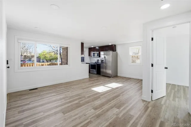 a view of empty room with wooden floor