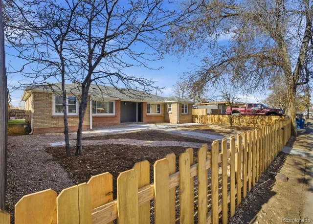 a view of a house with wooden fence