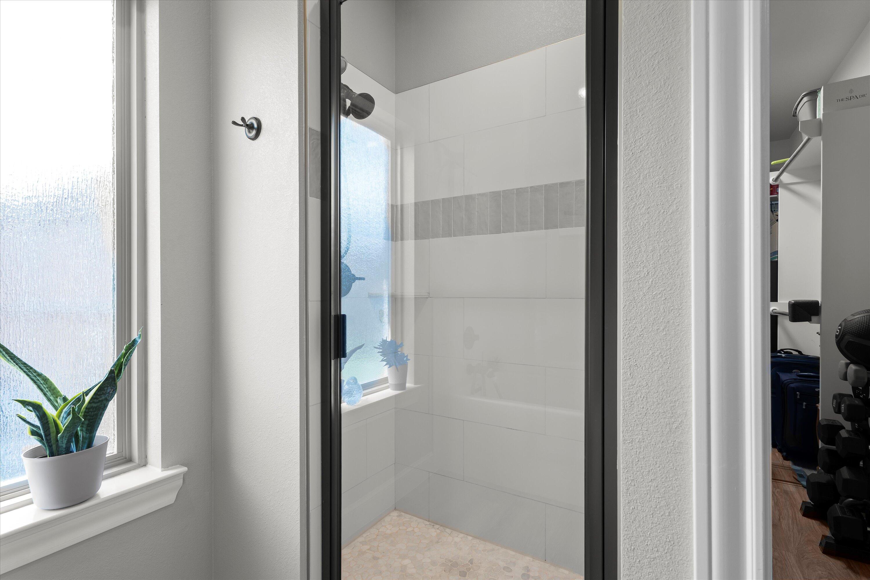 7002 103rd Street Lubbock, TX 79424 - Photo 19 of 35 a bathroom with a glass shower door and mirror