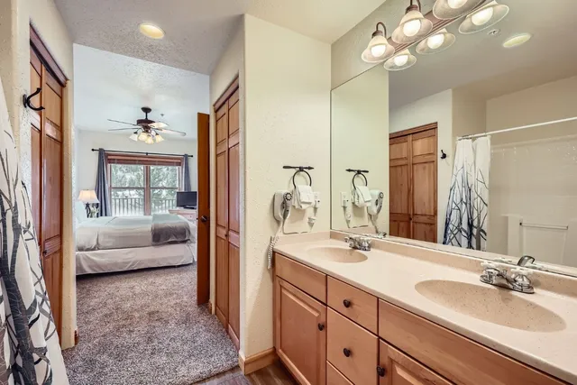 a en suite bathroom with a granite countertop sink a large mirror and shower