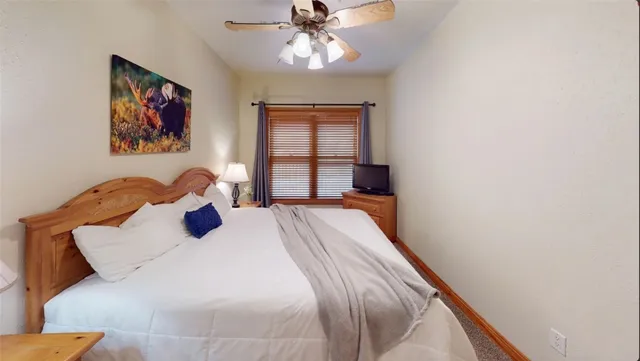 a bedroom with a bed and a lamp next to a window