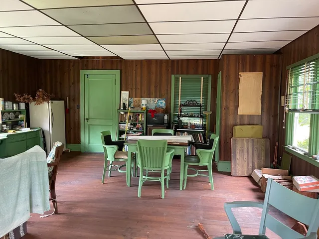 a dining room with furniture a livingroom view and wooden floor