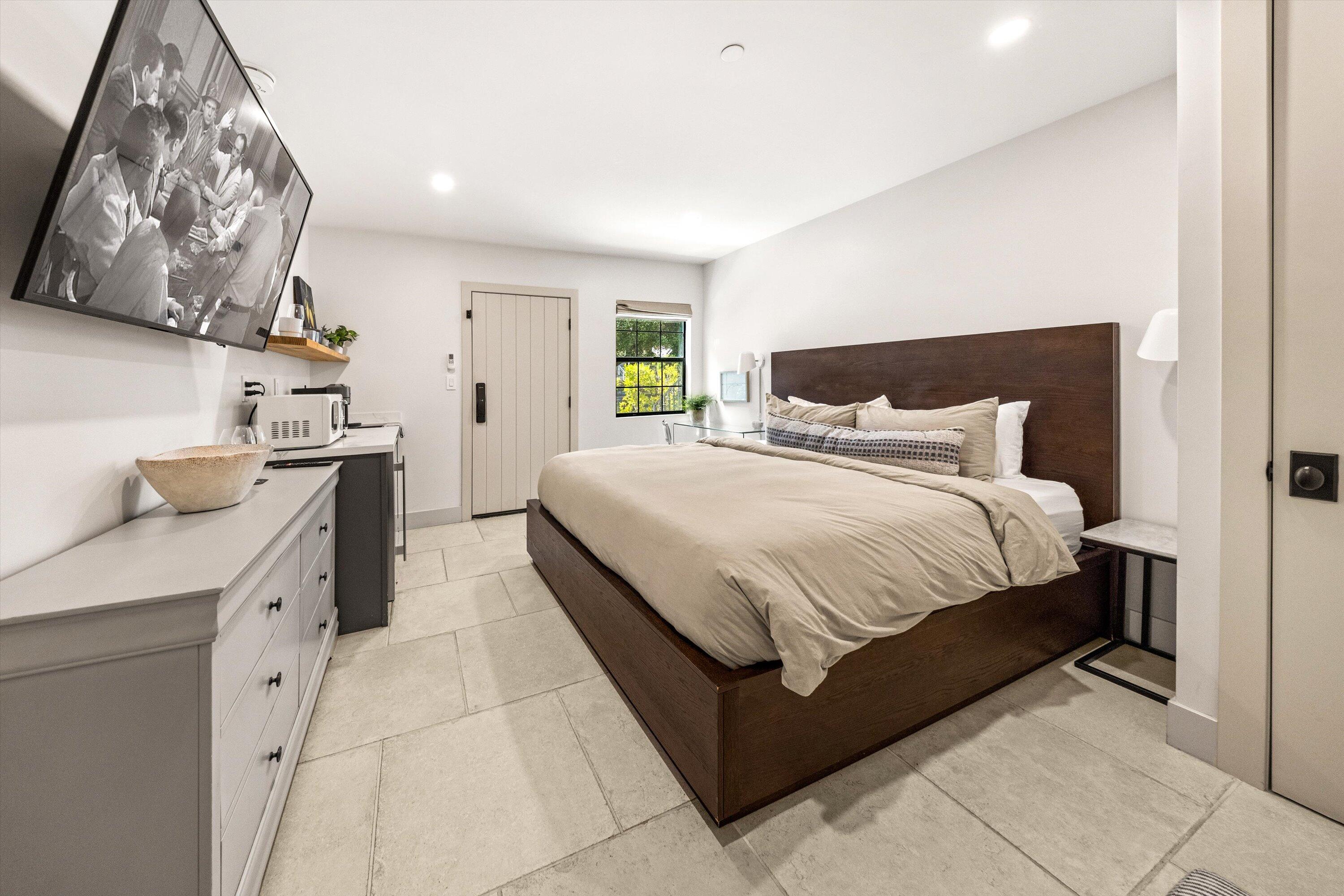 6 East Valerio Street Santa Barbara, CA 93101 - Photo 17 of 74 a bedroom with a large bed and a chandelier