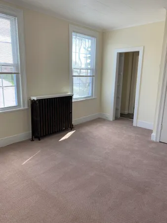 an empty room with windows and closet