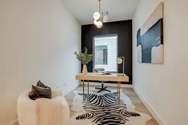 a living room with furniture a kitchen view and a refrigerator