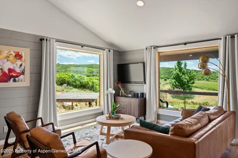 a living room with furniture kitchen view and a flat screen tv