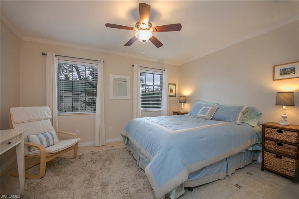 217 Bobolink Way, Unit 217B Naples, FL 34105 - Photo 6 of 17 a bedroom with a bed chairs and window