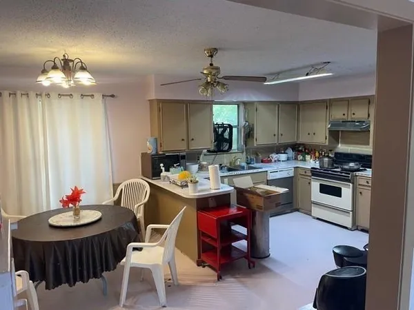 a kitchen with a dining table chairs sink and stove