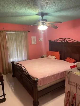 a bed sitting in a bedroom next to a window