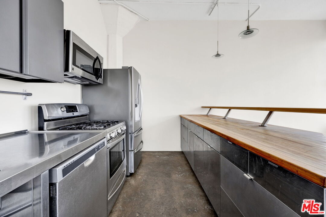 315 East 8th Street, Unit 1102 Los Angeles, CA 90014 - Photo 14 of 34 a kitchen with stainless steel appliances granite countertop a sink stove and refrigerator