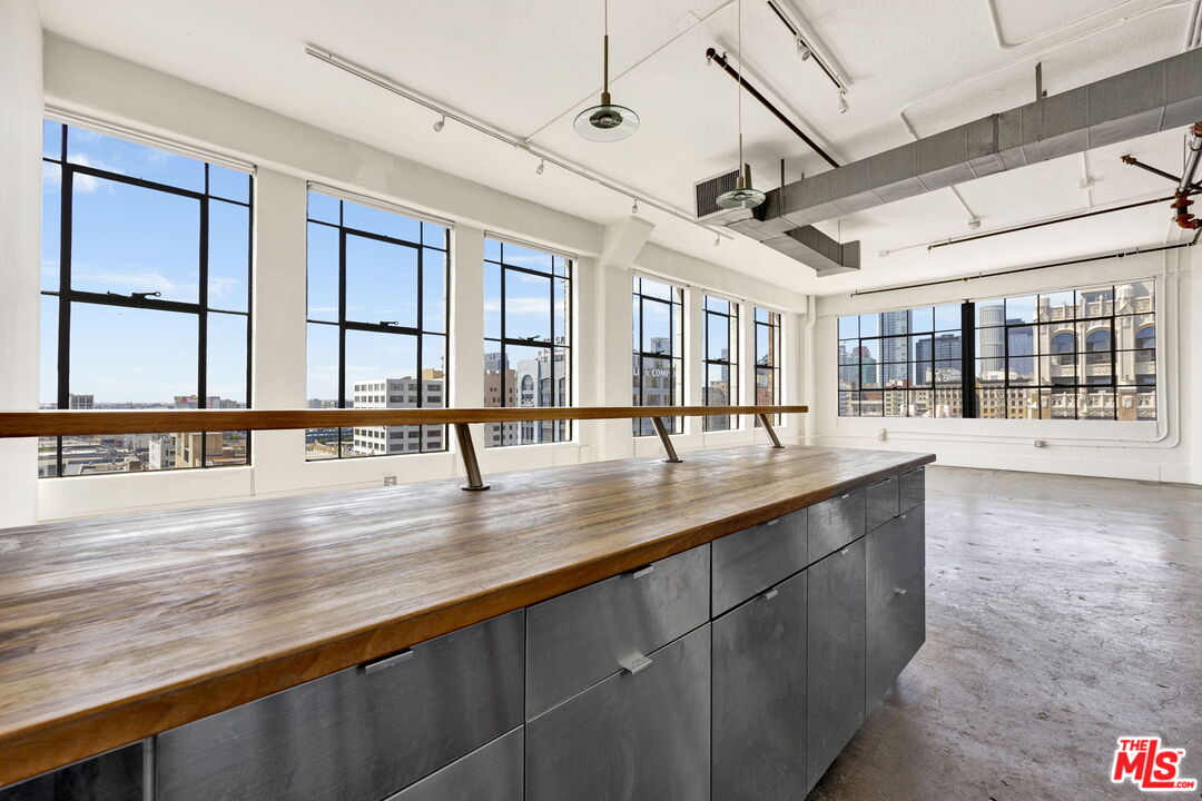 315 East 8th Street, Unit 1102 Los Angeles, CA 90014 - Photo 15 of 34 a view of a living room and kitchen with furniture large windows