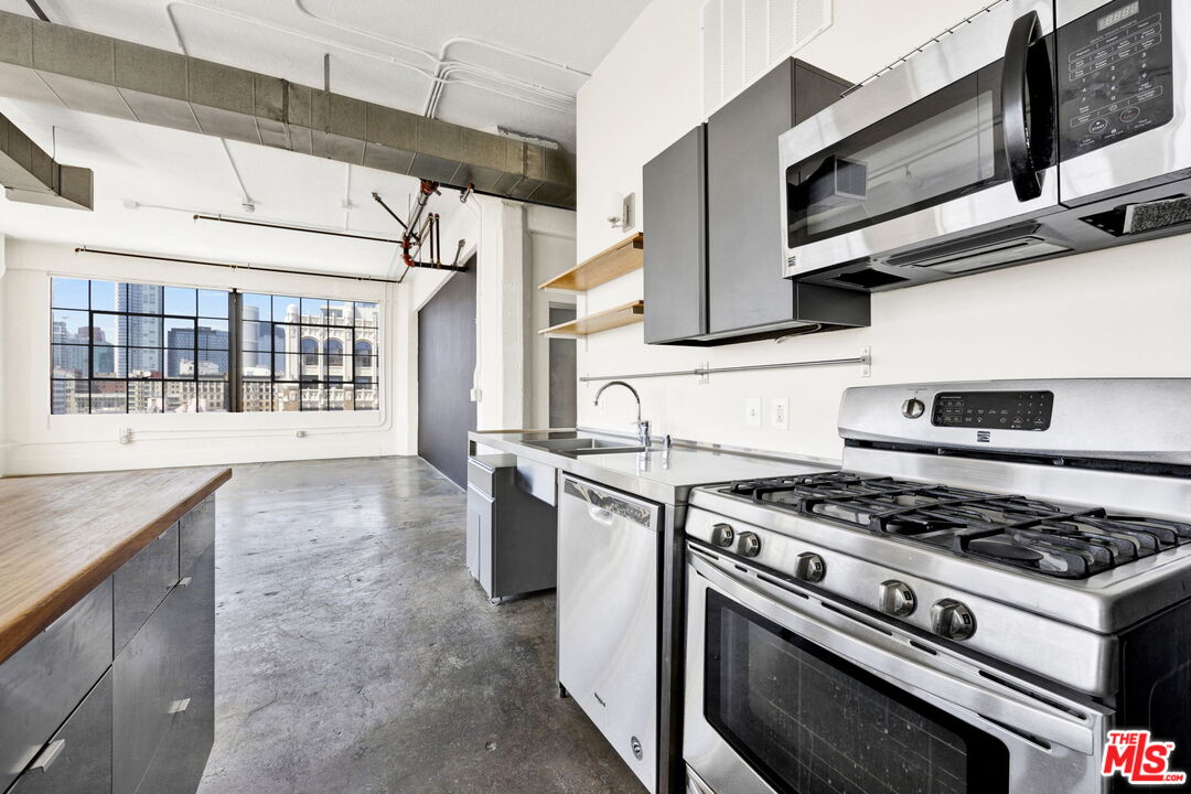315 East 8th Street, Unit 1102 Los Angeles, CA 90014 - Photo 16 of 34 a kitchen with stainless steel appliances granite countertop a stove and a sink