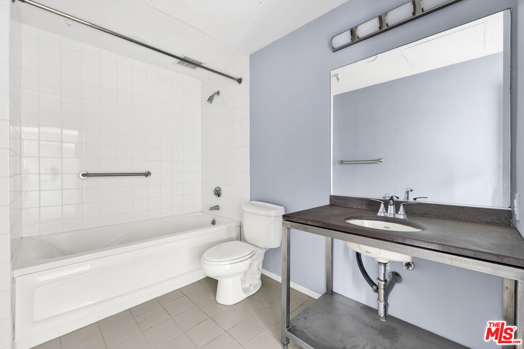 315 East 8th Street, Unit 1102 Los Angeles, CA 90014 - Photo 19 of 34 a bathroom with a granite countertop sink a toilet and bathtub