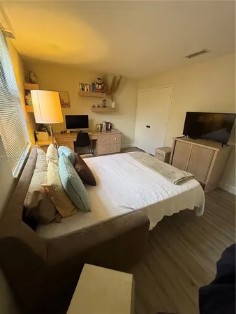 a bedroom with a bed and wooden floor