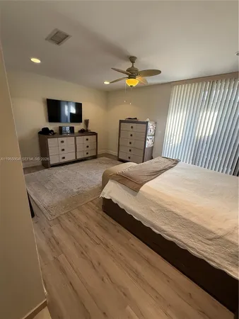 a spacious bedroom with a bed and a flat screen tv