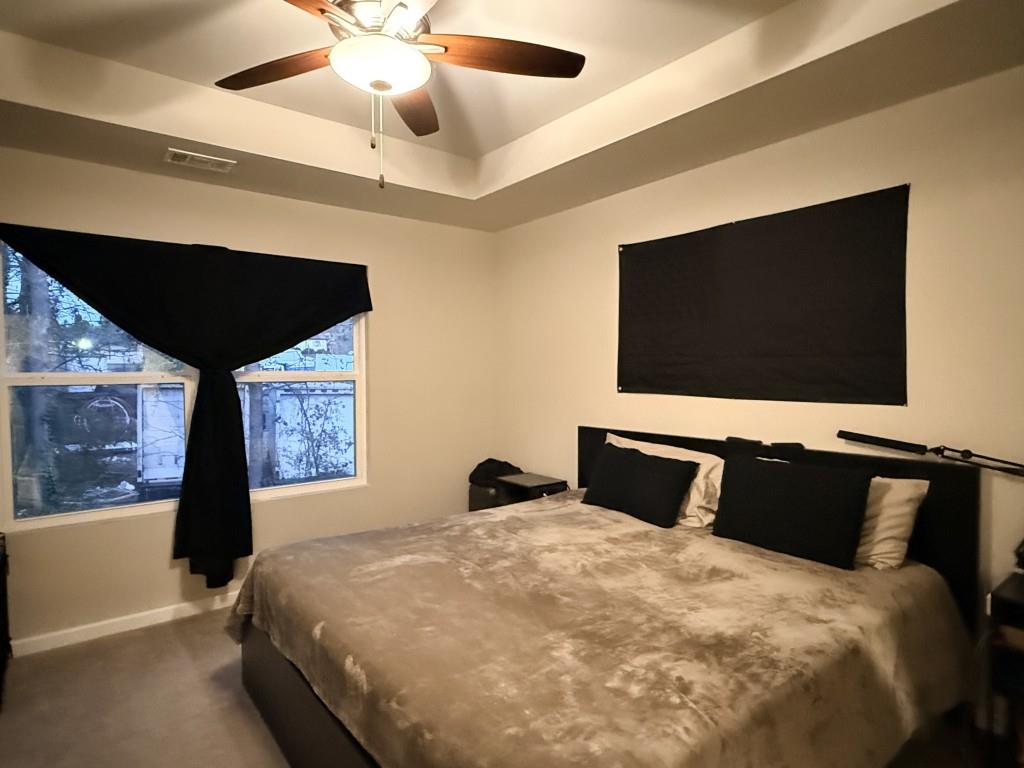 6271 Redan Square, Unit 83 Lithonia, GA 30058 - Photo 8 of 10 a bedroom with a bed and a flat tv screen