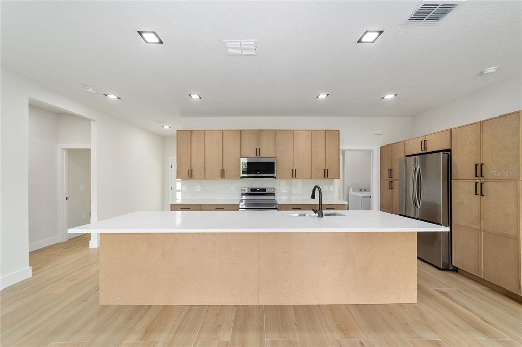 4380 Southwest 159th Court Ocala, FL 34481 - Photo 14 of 44 a large kitchen with stainless steel appliances a large counter top and a refrigerator