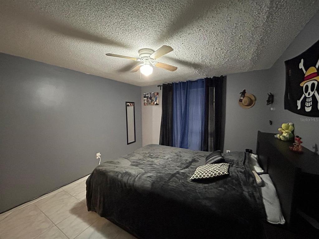 Undisclosed Address New Port Richey, FL 34652 - Photo 24 of 25 a bedroom with a bed and a chandelier