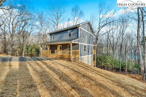 a view of a house with backyard and trees