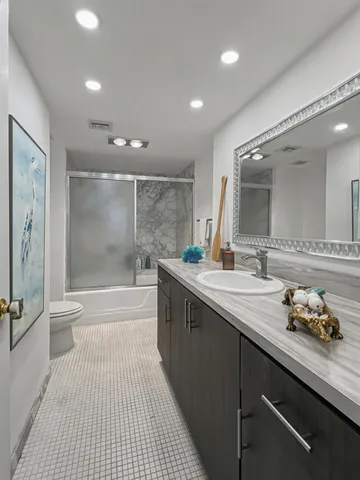 a bathroom with a sink a toilet and shower