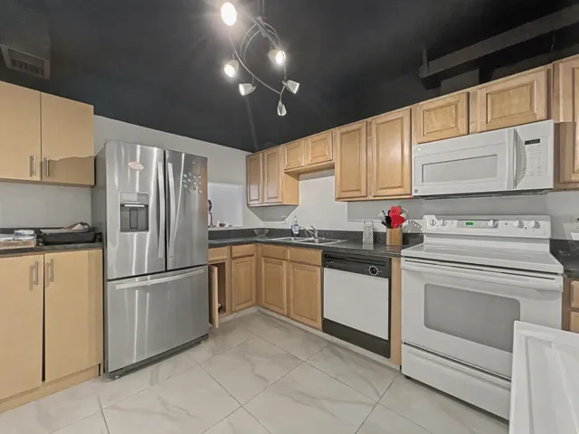 a kitchen with granite countertop stainless steel appliances and white cabinets