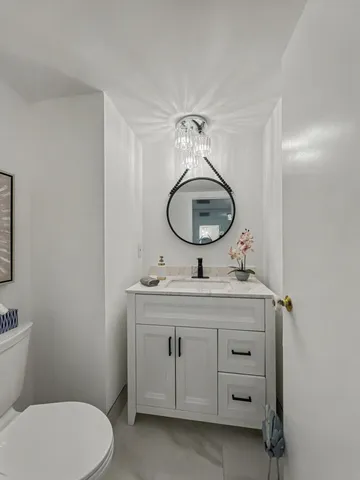 a bathroom with a toilet a sink and a mirror
