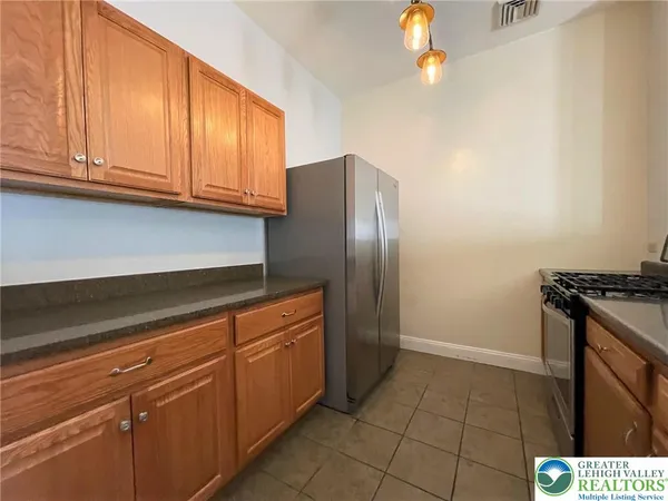 a kitchen with stainless steel appliances granite countertop a refrigerator and a stove top oven