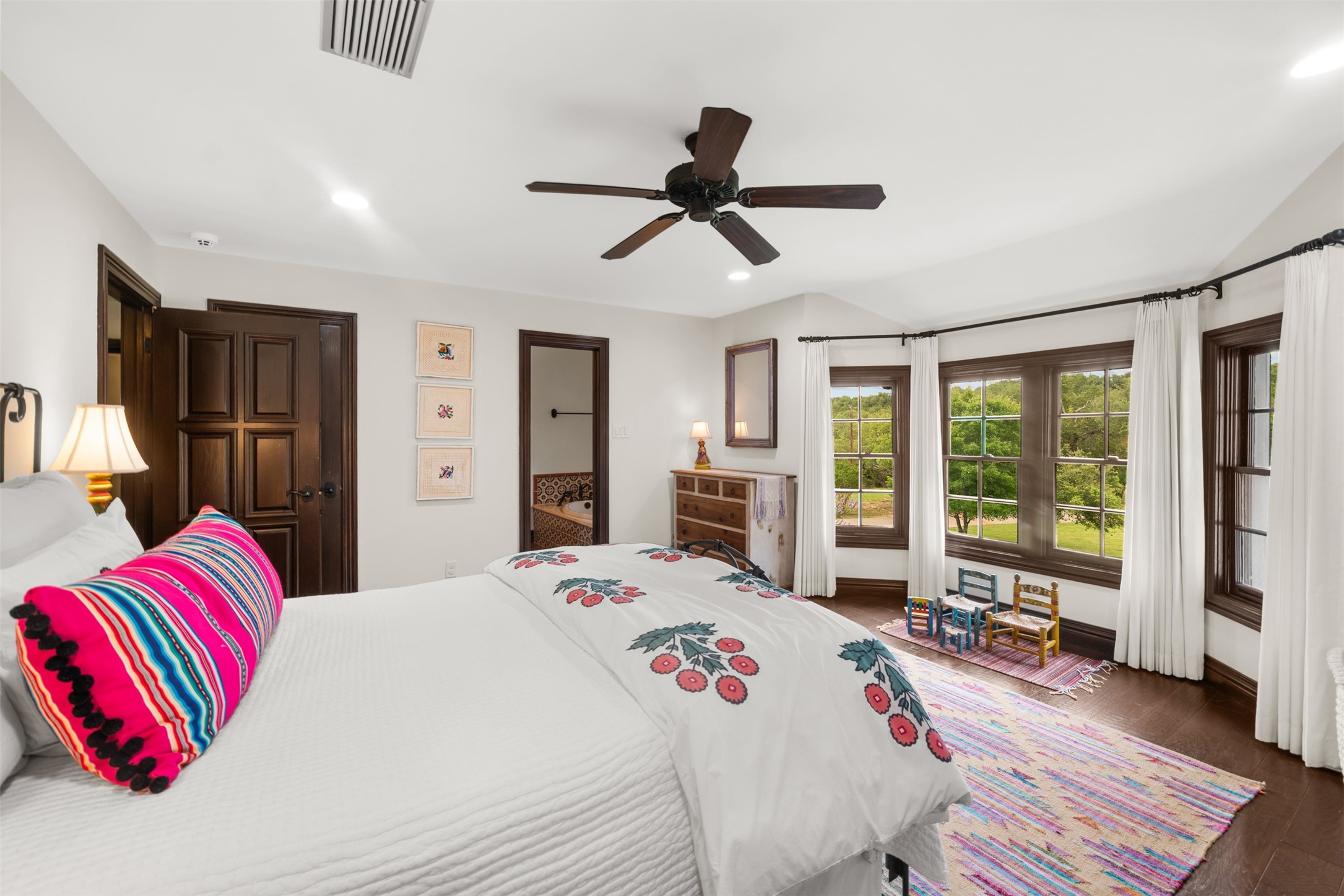 34000 Smithson Valley Road Bulverde, TX 78163 - Photo 22 of 50 Bright and welcoming, this secondary bedroom offers hardwood flooring, large windows, and picturesque views of the surrounding property. A comfortable retreat with plenty of space for family or guests.