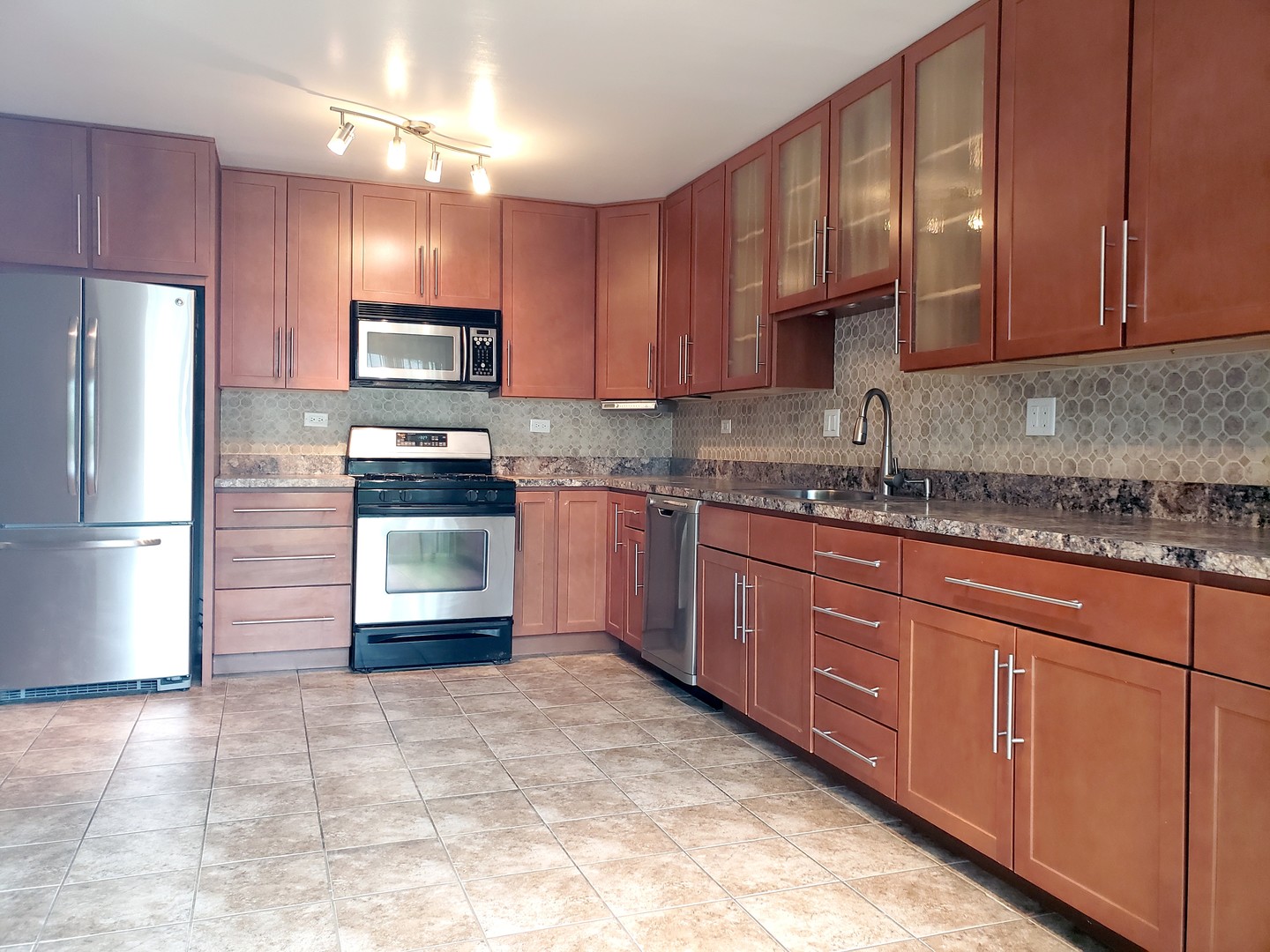 413 Harmony Drive Wheeling, IL 60090 - Photo 6 of 19 a kitchen with stainless steel appliances granite countertop a stove refrigerator a sink dishwasher and wooden cabinets