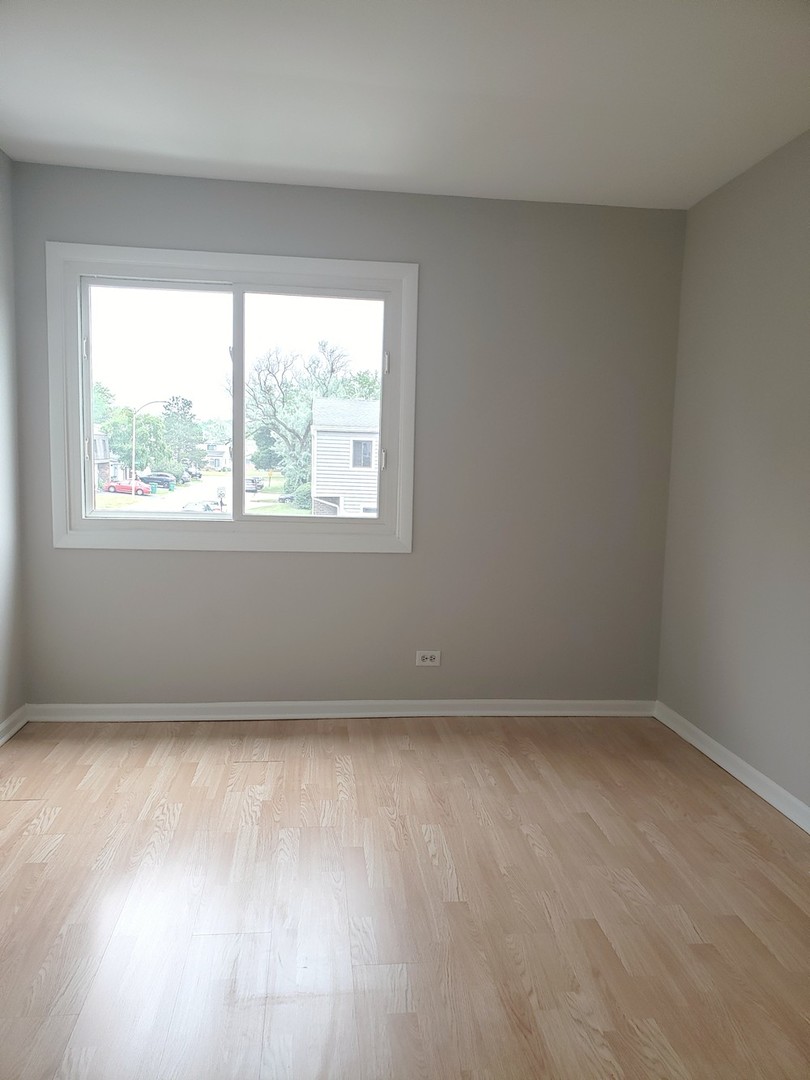 413 Harmony Drive Wheeling, IL 60090 - Photo 10 of 19 an empty room with wooden floor and windows