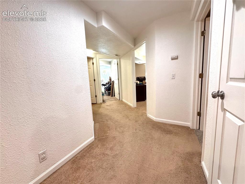 9362 St.George Road Peyton, CO 80831 - Photo 25 of 32 a view of a hallway with wooden shelves