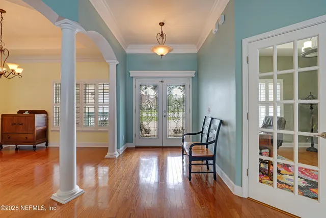 a living room with couches a fireplace and a dining table with wooden floor