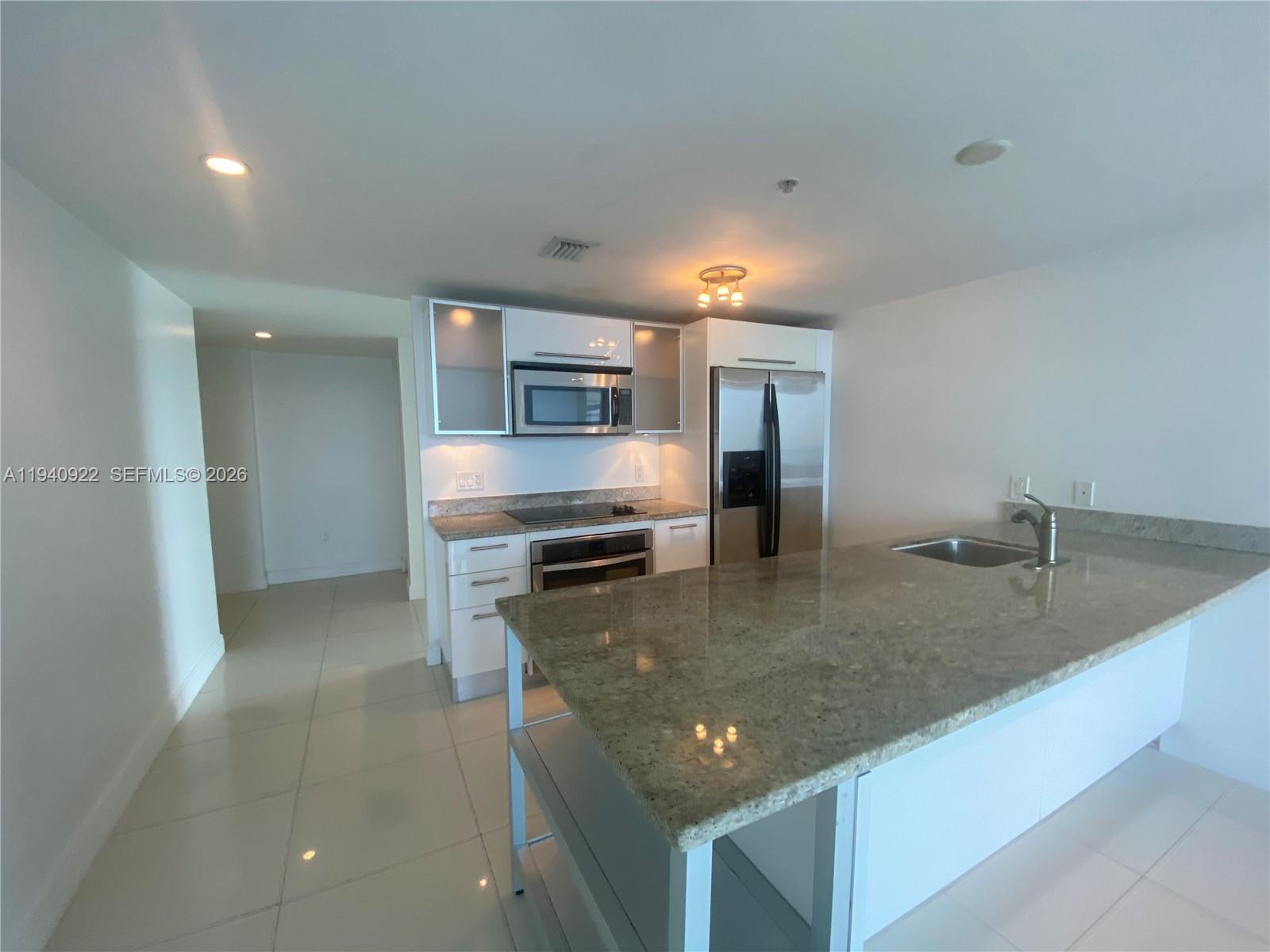 185 Southwest 7th Street, Unit 501 Miami, FL 33130 - Photo 24 of 31 a kitchen with stainless steel appliances granite countertop a sink a stove and a refrigerator
