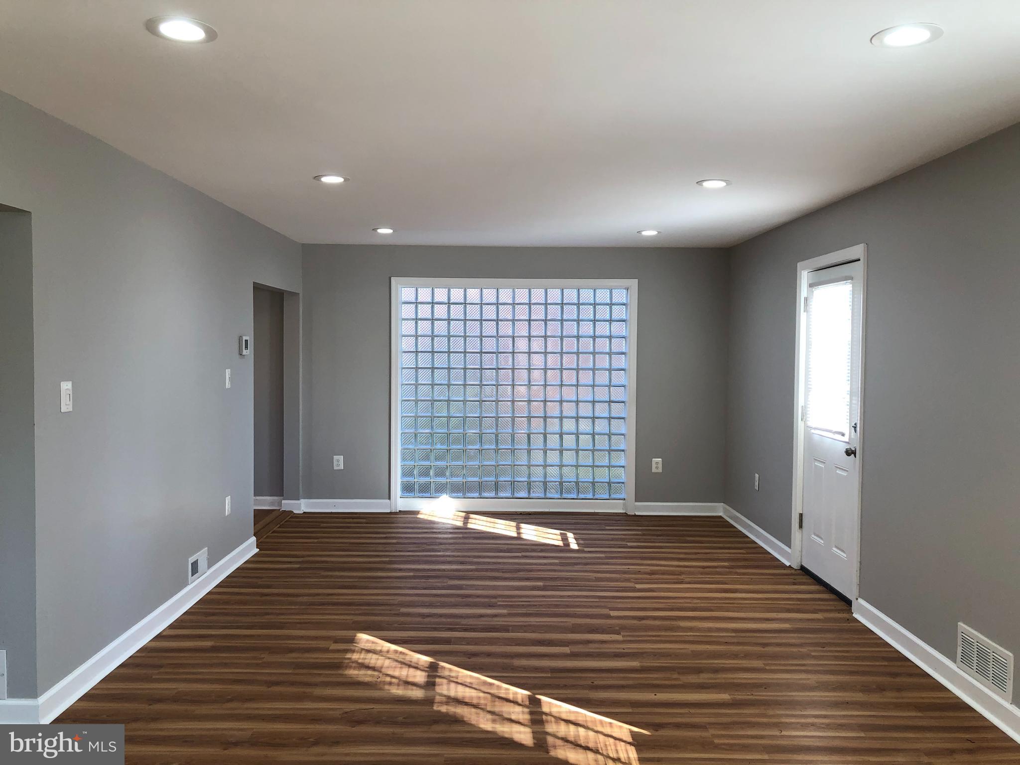 9925 Sutherland Road Silver Spring, MD 20901 - Photo 3 of 15 a view of an empty room with wooden floor and a window