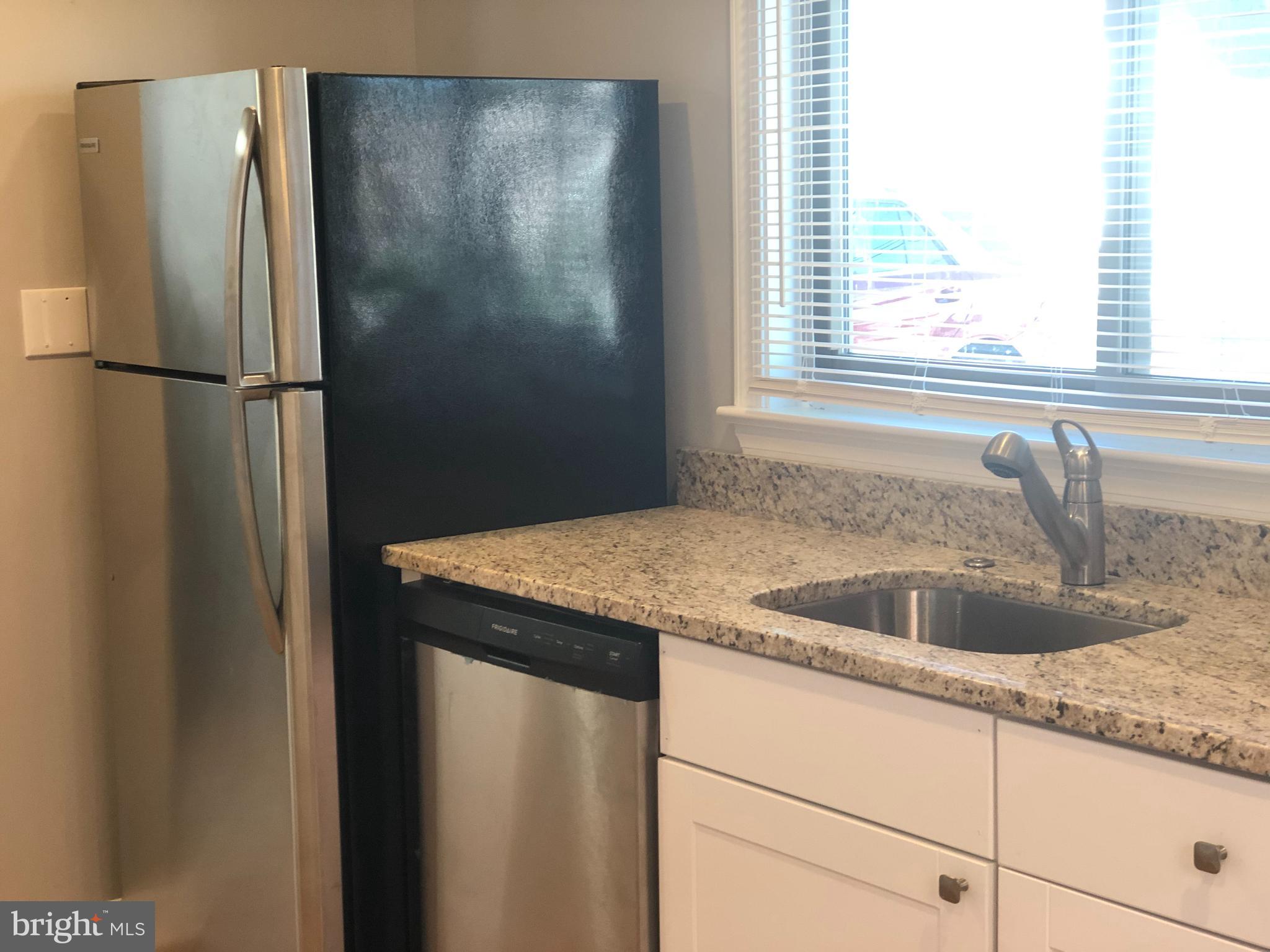 9925 Sutherland Road Silver Spring, MD 20901 - Photo 5 of 15 a kitchen with a granite countertop sink and refrigerator