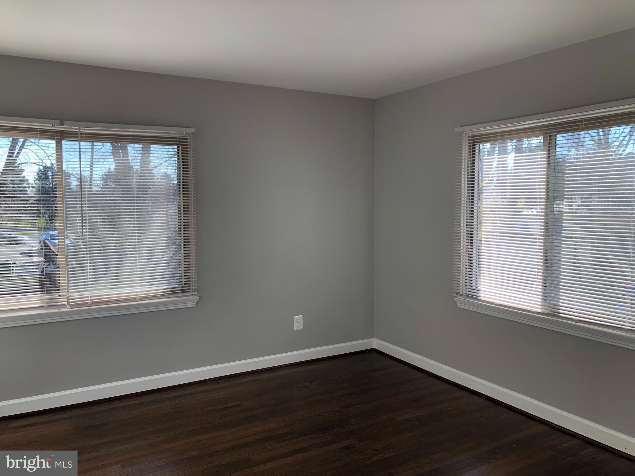 9925 Sutherland Road Silver Spring, MD 20901 - Photo 8 of 15 a view of an empty room with wooden floor and a window