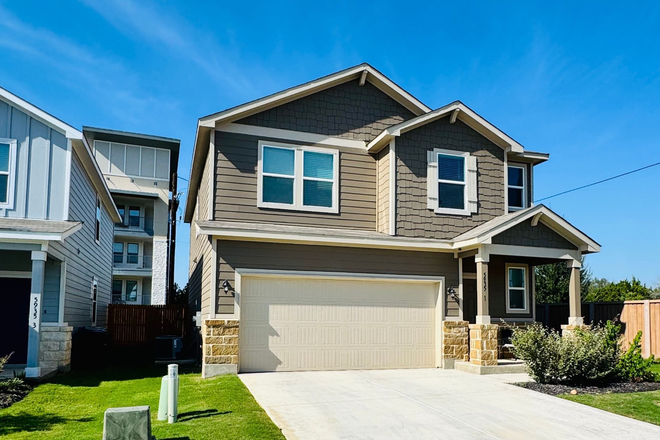 5935 West Hausman Road, Unit 1 San Antonio, TX 78249 - Photo 1 of 14 Craftsman house with stone siding, an attached garage, and driveway