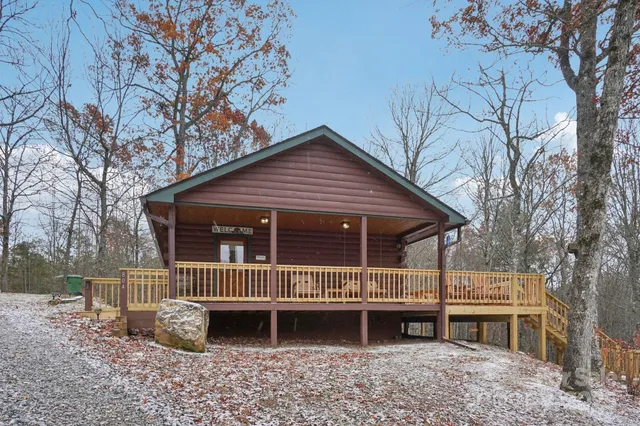 a view of a house with a yard and large tree