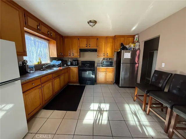 a kitchen with stainless steel appliances granite countertop a refrigerator and a stove