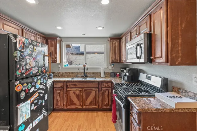 a kitchen with stainless steel appliances granite countertop a sink stove and cabinets