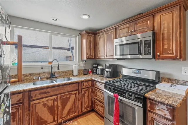 a kitchen with stainless steel appliances granite countertop a stove a sink dishwasher and a microwave oven with granite countertops
