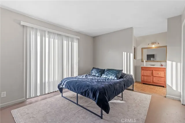 a bedroom with a bed and a view of kitchen