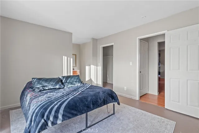 a bedroom with a large bed and wooden floor