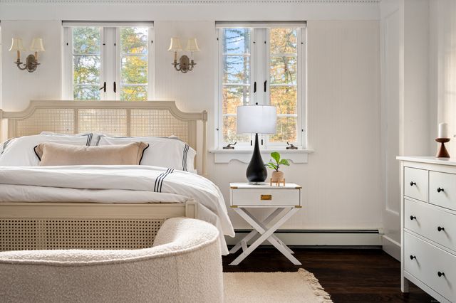 a living room with furniture two window and wooden floor